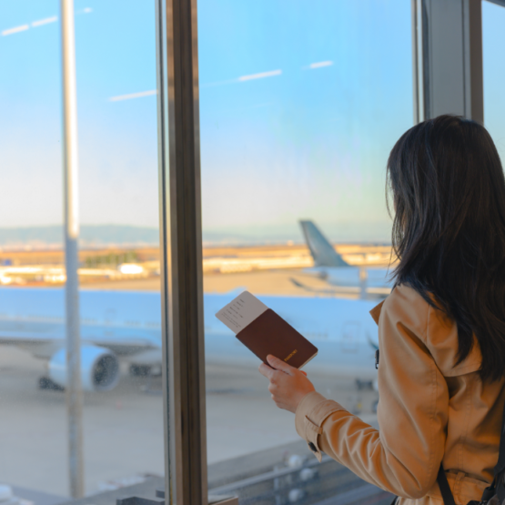 Imagem de uma mulher olhando o avião em aeroporto